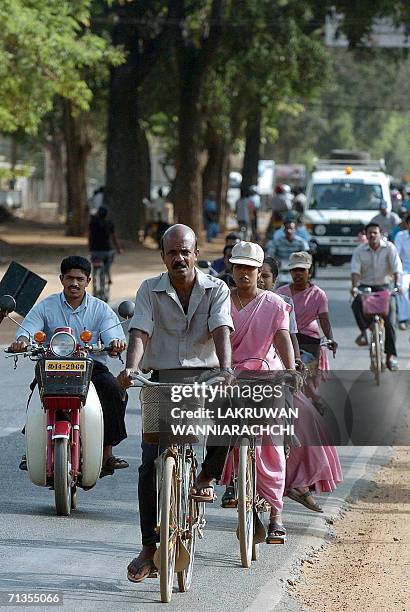 Sri Lankan commuters make their way on the main street of the rebel-held town of Kilinochchi, some 250 kilometers north of Colombo, early 03 July...