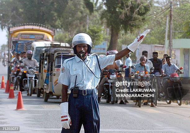 Liberation Tigers of Tamil Eelam police officer directs early morning traffic on the main street of the rebel-held town of Kilinochchi, some 250...
