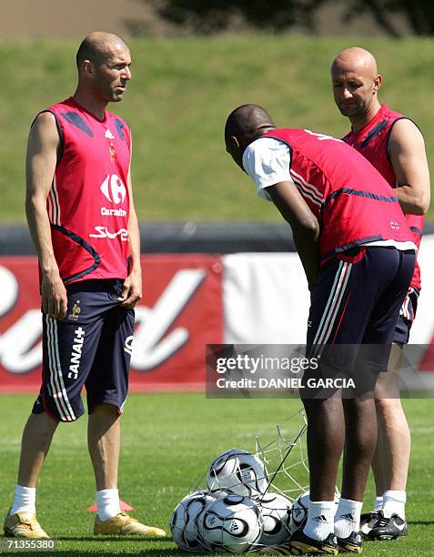French midfielder Zinedine Zidane , midfielder Patrick Vieira and goalkeeper Fabien Barthez open a bag full of footballs as they take part in a team...