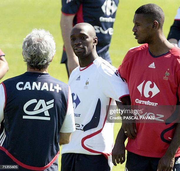 French football defender Eric Abidal and midfielder Claude Makelele talk to head coach Raymond Domenech during a team training session at...