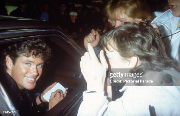 American actor and singer David Hasselhoff, star of TV series 'Knight Rider' signing an autograph for a fan, mid 1980s.