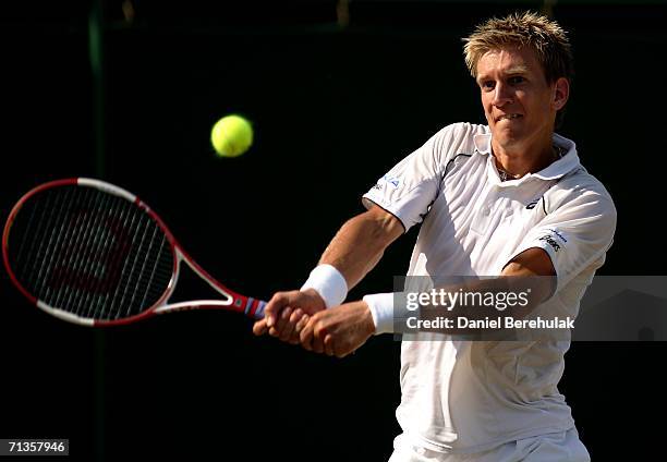 Jarkko Nieminen of Finland plays a backhand to Dmitry Tursunov of Russia during day seven of the Wimbledon Lawn Tennis Championships at the All...