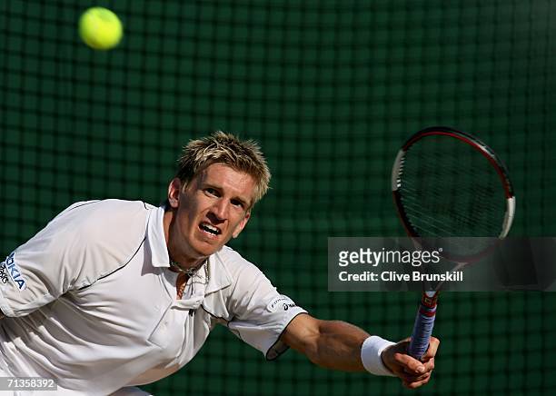 Jarkko Nieminen of Finland plays a forehand to Dmitry Tursunov of Russia during day seven of the Wimbledon Lawn Tennis Championships at the All...