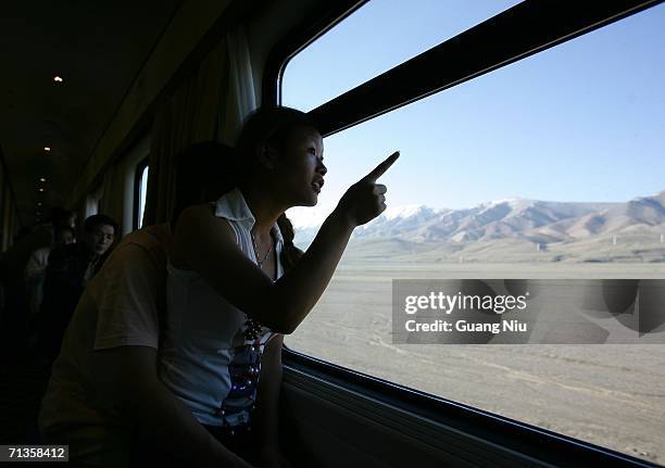 Passenger looks outside at the first train to travel from Beijing to the Tibetan capital Lhasa runs after it leaves Golmud station on July 3, 2006 in...