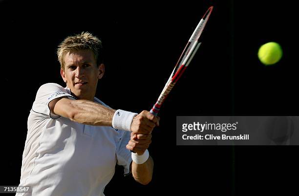 Jarkko Nieminen of Finland plays a backhand to Dmitry Tursunov of Russia during day seven of the Wimbledon Lawn Tennis Championships at the All...