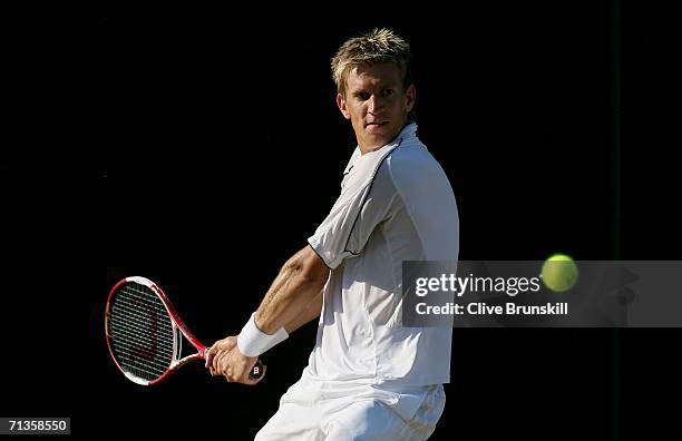 Jarkko Nieminen of Finland plays a backhand to Dmitry Tursunov of Russia during day seven of the Wimbledon Lawn Tennis Championships at the All...