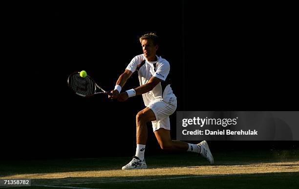 Jarkko Nieminen of Finland plays a backhand to Dmitry Tursunov of Russia during day seven of the Wimbledon Lawn Tennis Championships at the All...