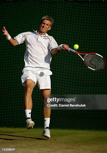 Jarkko Nieminen of Finland plays a forehand to Dmitry Tursunov of Russia during day seven of the Wimbledon Lawn Tennis Championships at the All...