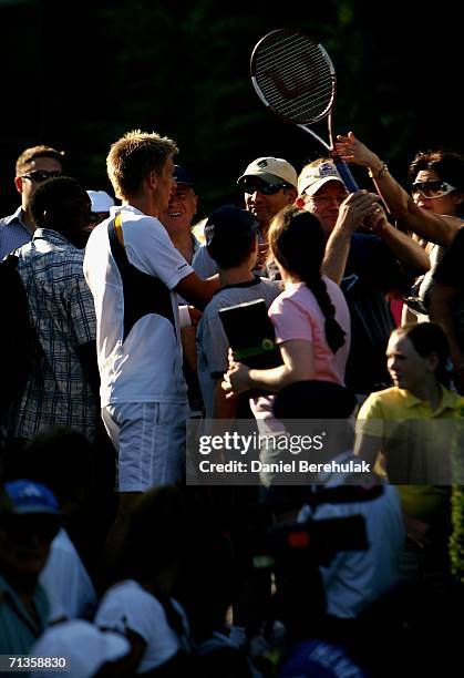 Jarkko Nieminen of Finland gets his racquet of a spectator during his match against Dmitry Tursunov of Russia during day seven of the Wimbledon Lawn...