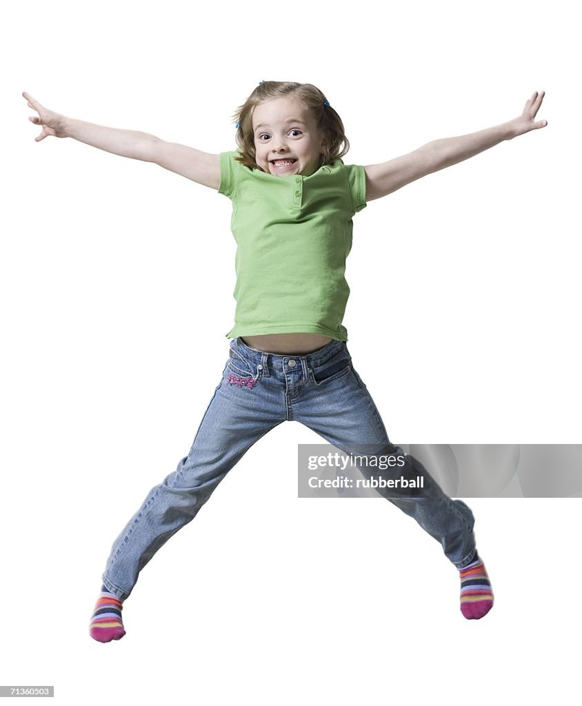 Portrait of a girl jumping in air with her arms outstretched