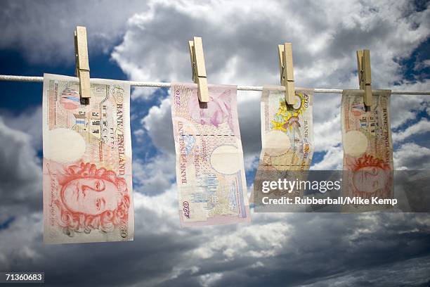 low angle view of english paper currency pegged on a clothesline - money laundering stock pictures, royalty-free photos & images