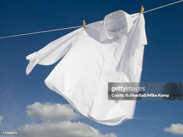 close-up of a shirt hanging on a clothesline - white laundry stock-fotos und bilder