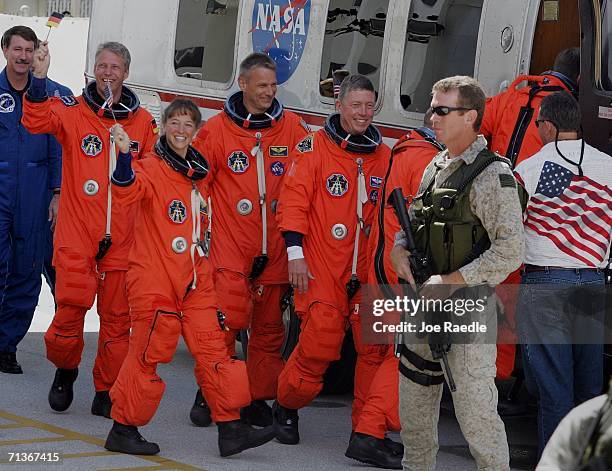 European Space Agency's Thomas Reiter of Germany, Mission Specialists Lisa Nowak, Piers Sellers and Mike Fossum walk out of the Operations and...