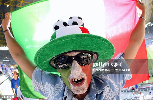 An Italian supporter with his national colours painted on his face holds his national flag prior to the World Cup 2006 semi final football game...