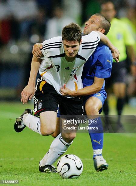 Arne Friedrich of Germany tangles with Alessandro Del Piero of Italy during the FIFA World Cup Germany 2006 Semi-final match between Germany and...