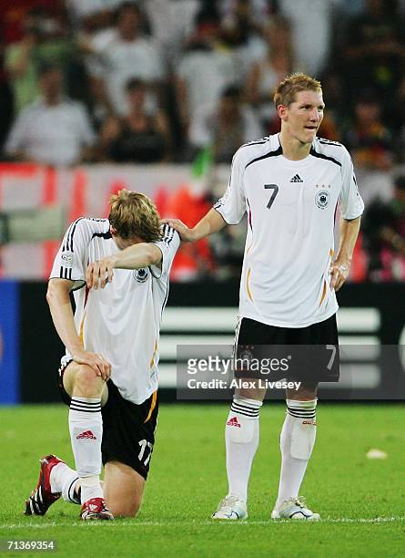 Per Mertesacker of Germany is consoled by team mate Bastian Schweinsteiger following their team's defeat at the end of the FIFA World Cup Germany...