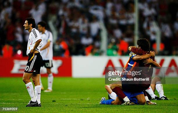 Gianluigi Buffon and Simone Barone of Italy celebrate as Oliver Neuville looks on dejectedly at the end of the FIFA World Cup Germany 2006 Semi-final...