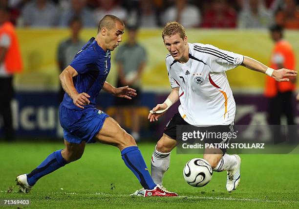 German midfielder Bastian Schweinsteiger tries to dribble Italian defender Fabio Cannavaro during the World Cup 2006 semi final football game Germany...