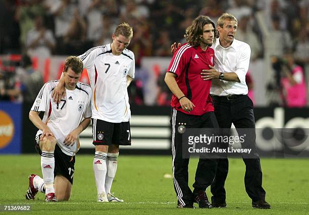 Per Mertesacker, Bastian Schweinsteiger, Torsten Frings of Germany and coach Jurgen Klinsmann look dejected following defeat during the FIFA World...