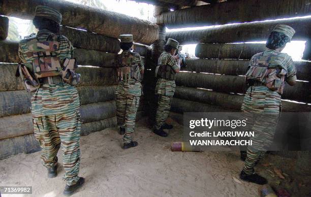 Female Liberation Tigers of Tamil Eelam guerrillas aim their weapons as they stand in a bunker located near the rebel front, 03 July 2006 north of...