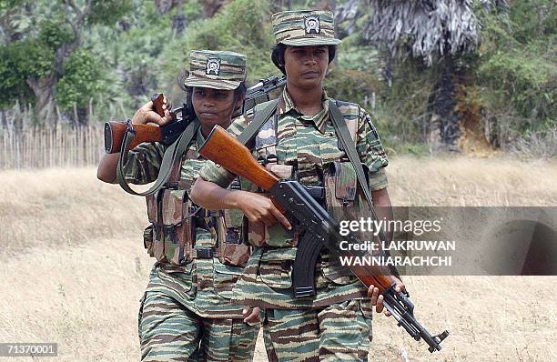 Female Liberation Tigers of Tamil Eelam guerrillas carry their weapons as they patrol outside their camp located near the rebel front, 03 July 2006...
