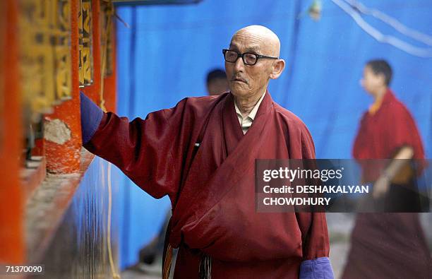 In this picture taken 04 July 2006, an Indian Buddhist monk rotates the prayer wheels at a monastery in Gangtok, capital city of the northeastern...