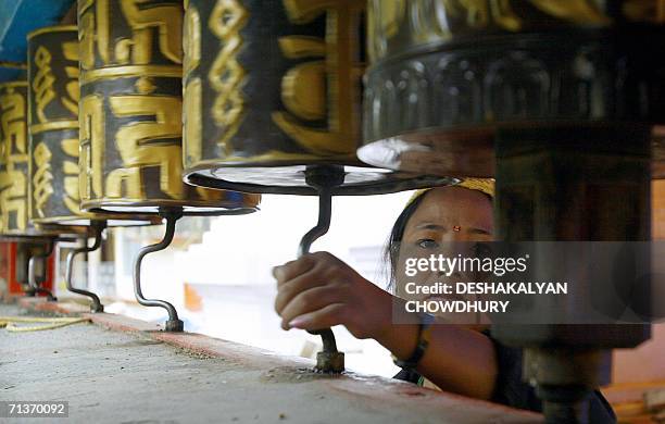 In this picture taken 04 July 2006, an Indian Buddhist woman rotates the prayer wheels at a monastery in Gangtok, capital city of the northeastern...