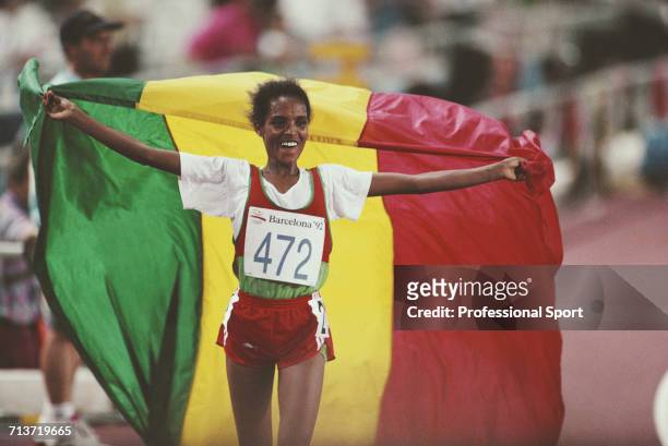 Ethiopian long distance runner Derartu Tulu celebrates with the national flag of Ethiopia after crossing the finish line in first place to win the...