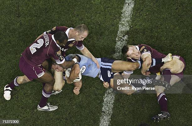 Matt Cooper of the Blues is trackled by Brent Tate of the Maroons during game three of the ARL State of Origin series between the New South Wales...