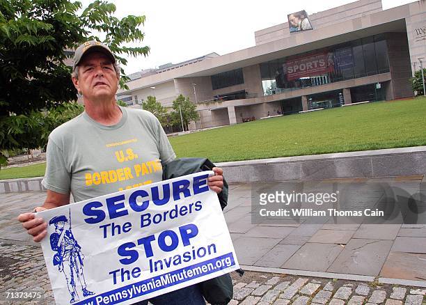 John Ryan of Quakertown, Pennsylvania holds a sign protesting outside a Senate Hearing on Illegal Immigration at the National Constitution Center...