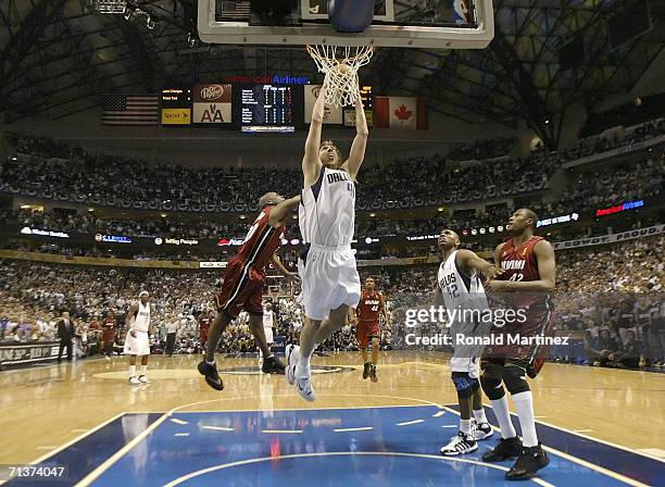 Dirk Nowitzki of the Dallas Mavericks slam dunks over Gary Payton of the Miami Heat in game six of the 2006 NBA Finals on June 20, 2006 at American...
