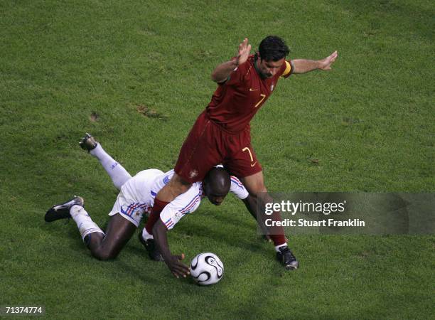 Luis Figo of Portugal tangles with Lilian Thuram of France during the FIFA World Cup Germany 2006 Semi-final match between Portugal and France at the...