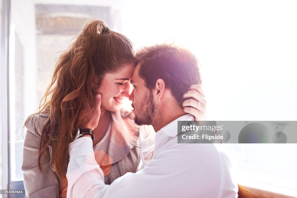 Romantic young couple face to face in office