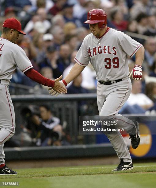 Third base coach Dino Ebel of the Los Angeles Angels of Anaheim congratulates Robb Quinlan on his three-run home run in the 5th inning against the...