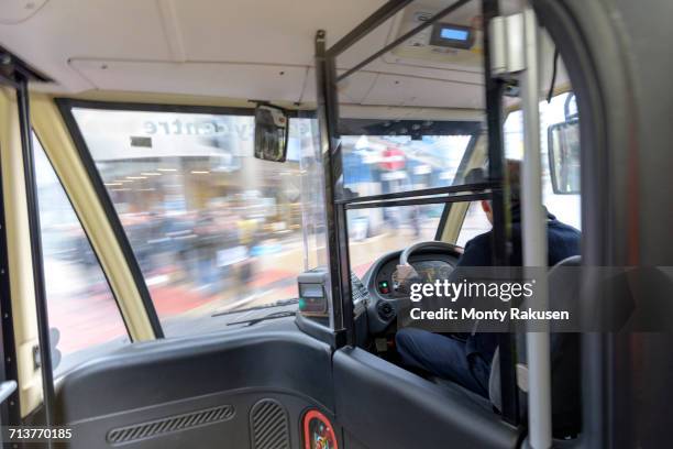 bus driver driving electric bus in traffic - bus driver stock pictures, royalty-free photos & images