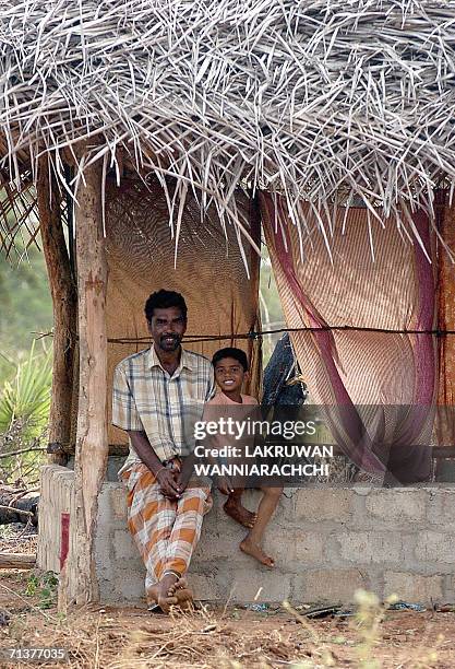In this picture taken 03 July 2006, Sri Lankan Tamil man P. Kanthamuddu and Paranidaran pose for photographs as they take a rest inside their...