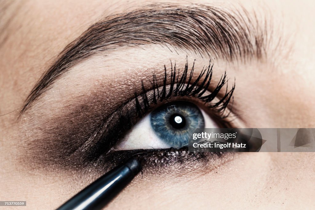 Close up of eyeliner being applied to young womans eye