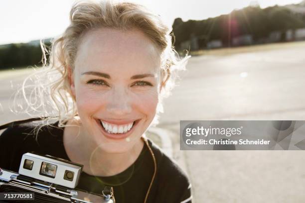portrait of happy mid adult woman with vintage camera - frauen mit fotoapparat stock-fotos und bilder