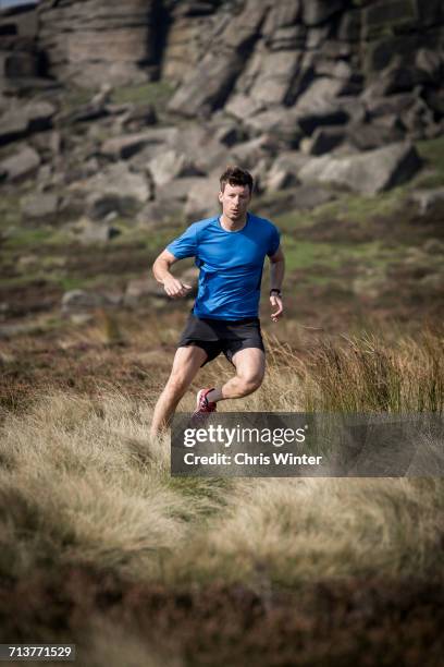 male runner running down from stanage edge, peak district, derbyshire, uk - shorts down stock pictures, royalty-free photos & images