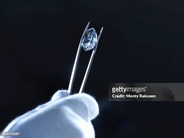 jeweller inspecting replica diamonds with gloved hand - examining diamond stock pictures, royalty-free photos & images