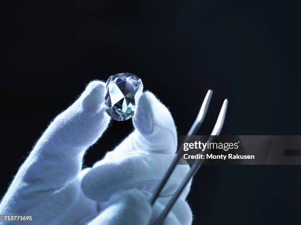 jeweller inspecting replica diamonds with gloved hand - examining diamond stock pictures, royalty-free photos & images