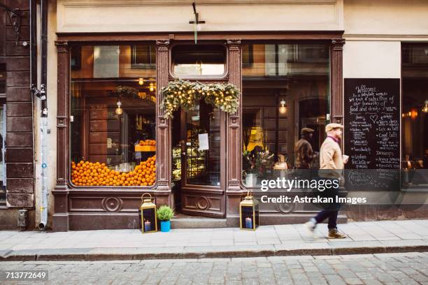 sweden, stockholm, gamla stan, man walking by cafe - hipster cafe stock pictures, royalty-free photos & images