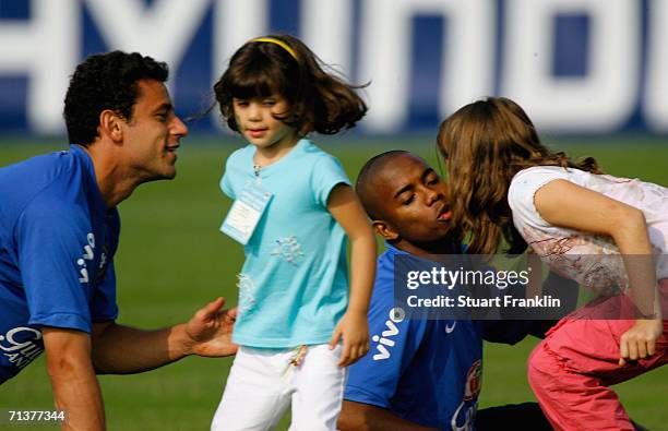 Juninho Pernambucano daughters kiss Fred and Robinho of Brazil during the Brazil National Football Team training session for the FIFA World Cup...