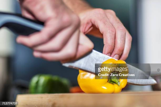 chef slicing yellow pepper, close-up - gele paprika stockfoto's en -beelden