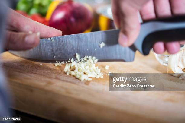 chef chopping fresh garlic, close-up - affettare foto e immagini stock