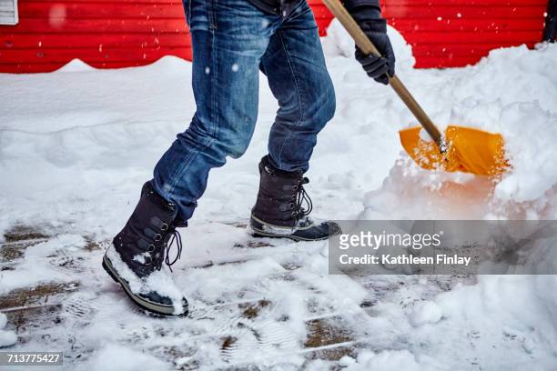 man shovelling snow from pathway, low section - skyffel bildbanksfoton och bilder