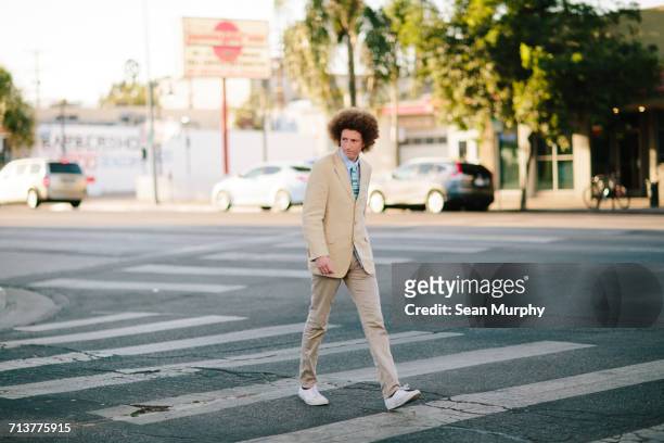 teenage boy with red afro hair, wearing suit, on pedestrian crossing - a la moda stock pictures, royalty-free photos & images