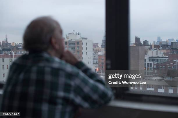 man looking out of window, manhattan, new york, usa - leaning on elbows stock pictures, royalty-free photos & images