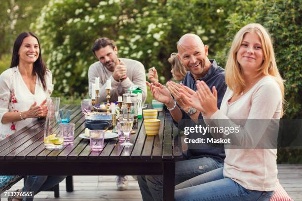 happy family and friend applauding while sitting at dining table in back yard during garden party - applauding fotografías e imágenes de stock