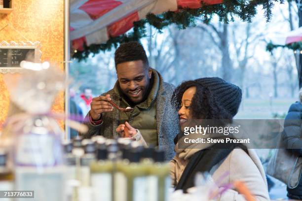 couple tasting food at food stall, new york, usa - trying new food stock pictures, royalty-free photos & images